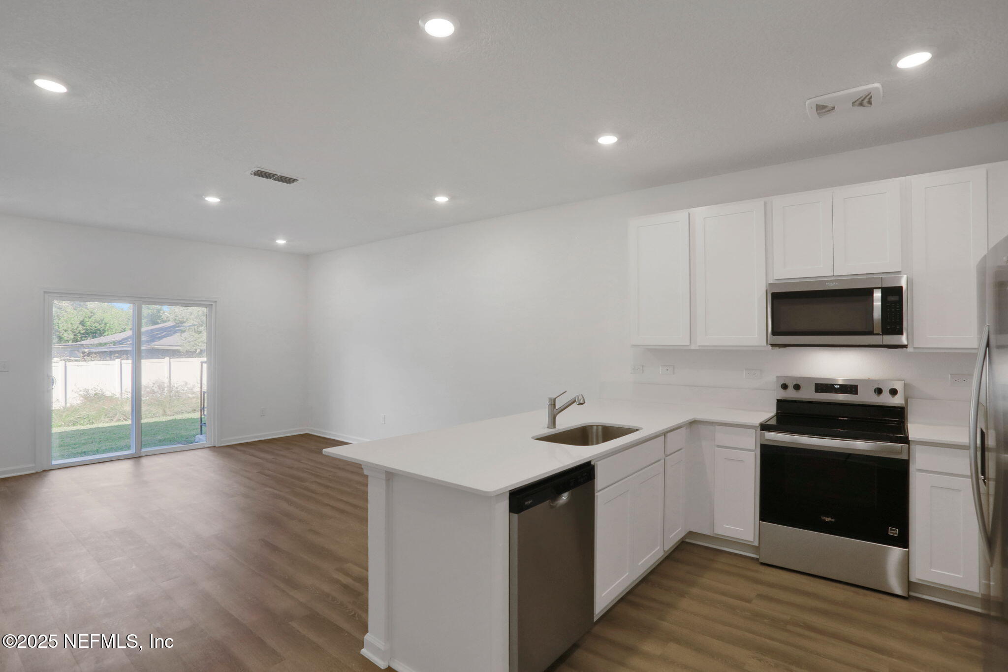 739 Sailor Grove Lane Jacksonville, FL 32221 - Photo 17 of 30 a kitchen with stainless steel appliances kitchen island granite countertop a stove a sink and a microwave