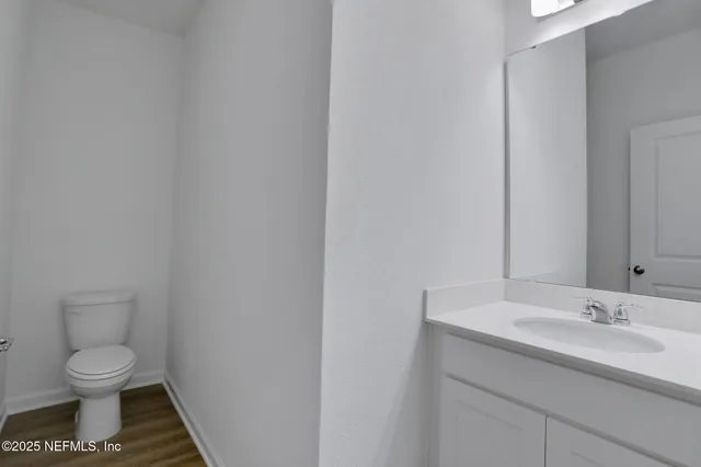 a bathroom with a toilet a sink and mirror