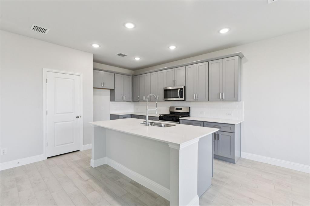 1318 Middlebrook Drive Forney, TX 75126 - Photo 3 of 39 a kitchen with cabinets and stainless steel appliances
