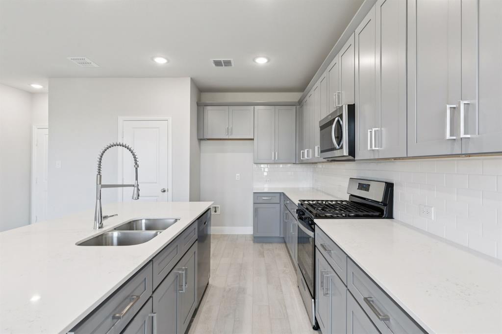 1318 Middlebrook Drive Forney, TX 75126 - Photo 4 of 39 a kitchen with a sink cabinets and stainless steel appliances