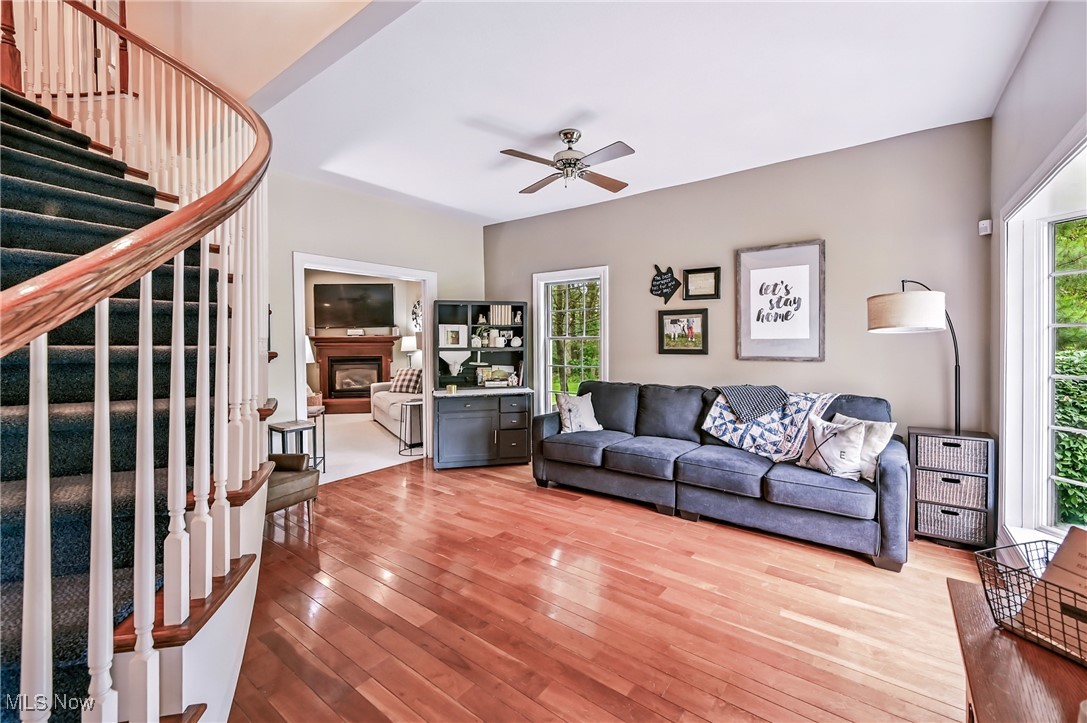 1681 State Road Northwest Warren, OH 44481 - Photo 22 of 50 Living room with stairway, wood flooring, a fireplace, and a ceiling fan
