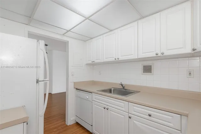 a kitchen with white cabinets and a sink