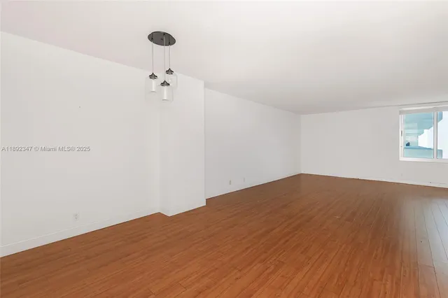 a view of a room with wooden floor and white walls