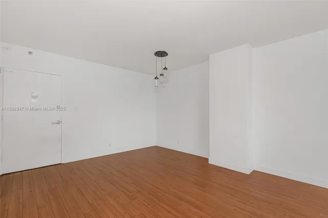 a view of a room with wooden floor and white walls