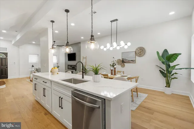 a view of a kitchen with kitchen island a sink and a chandelier