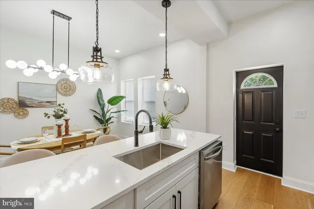 a kitchen with kitchen island a sink and a chandelier