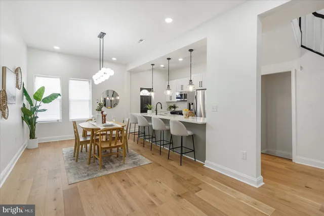 a view of a a dining room with furniture wooden floor and a chandelier