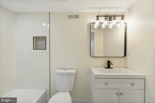 a bathroom with a sink a toilet and mirror