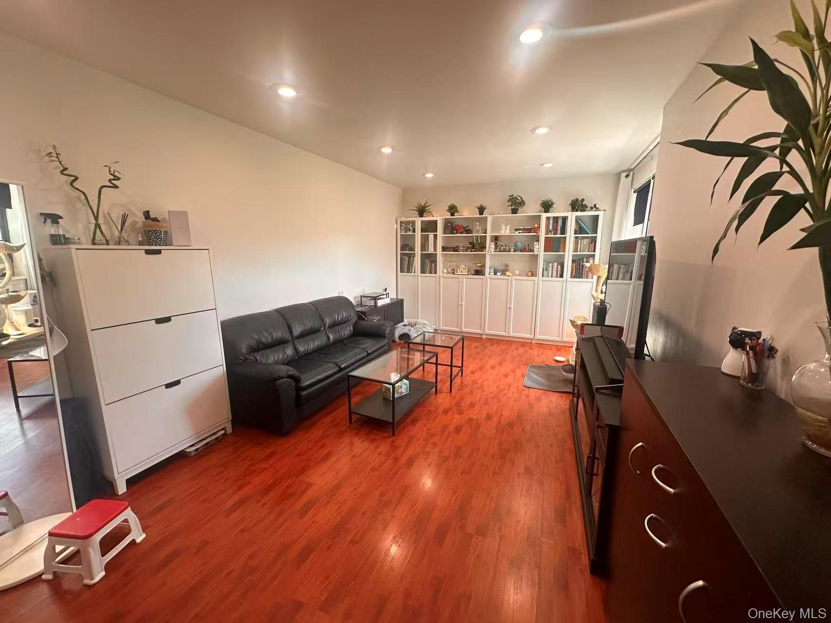 139-15 28th Road, Unit 6G Queens, NY 11354 - Photo 5 of 20 a living room with furniture and wooden floor