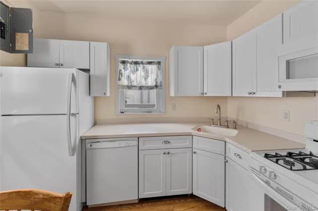a kitchen with cabinets appliances a sink and a window