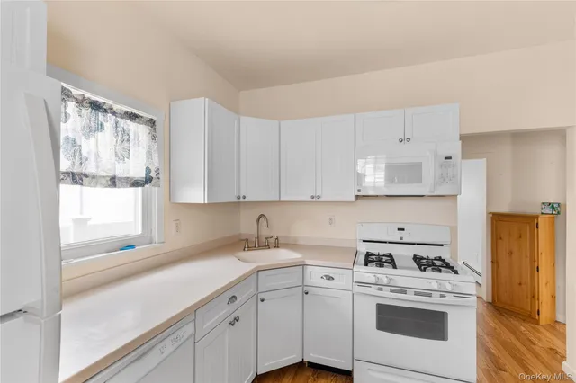 a kitchen with cabinets appliances a sink and a window