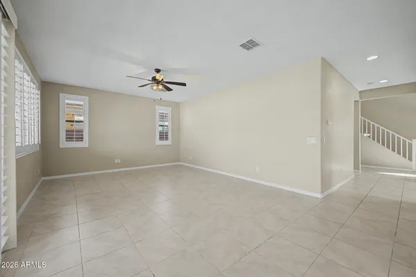 an empty room with windows and fan