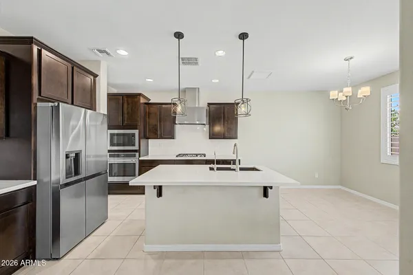 a kitchen with stainless steel appliances granite countertop a sink a stove a refrigerator and a oven