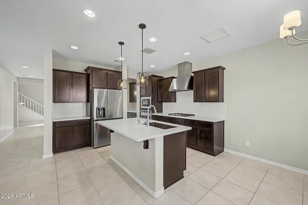 a kitchen with stainless steel appliances granite countertop a sink a stove a refrigerator and a oven