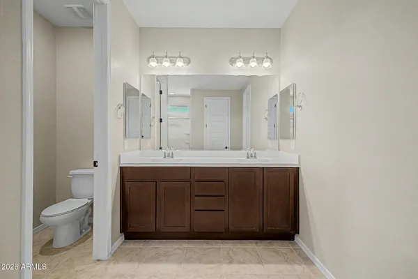 a spacious bathroom with a toilet a sink and a large mirror