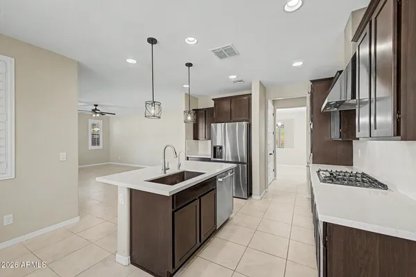a kitchen with stainless steel appliances granite countertop a refrigerator a sink and wooden floor