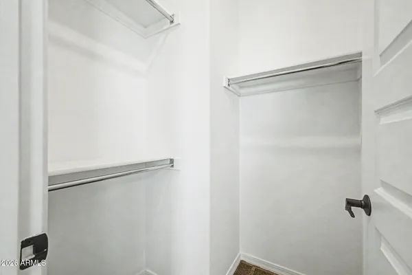 an empty room with closet and a chandelier fan