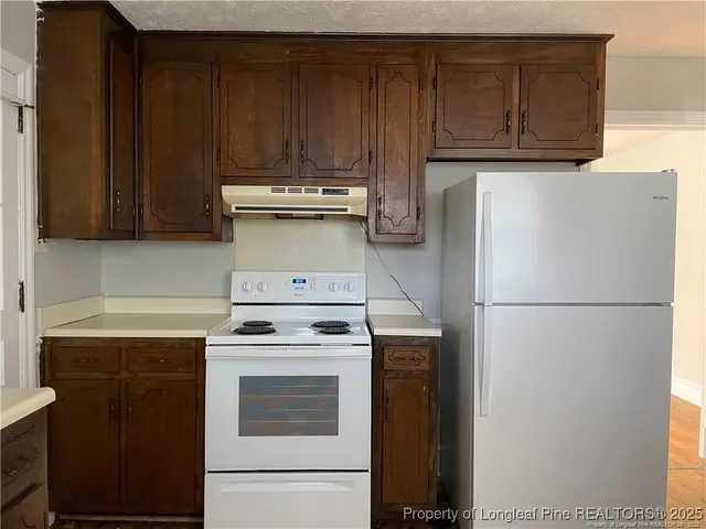 a kitchen with a stove top oven and cabinets