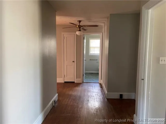 an empty room with wooden floor a ceiling fan and closet