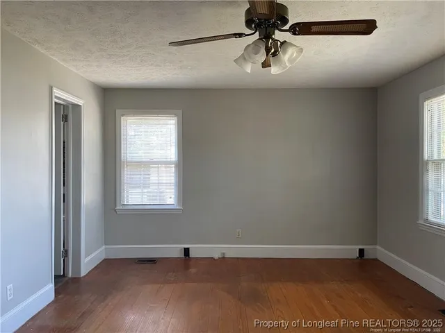 an empty room with a window and a ceiling fan