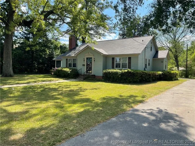 a front view of house with yard and trees around