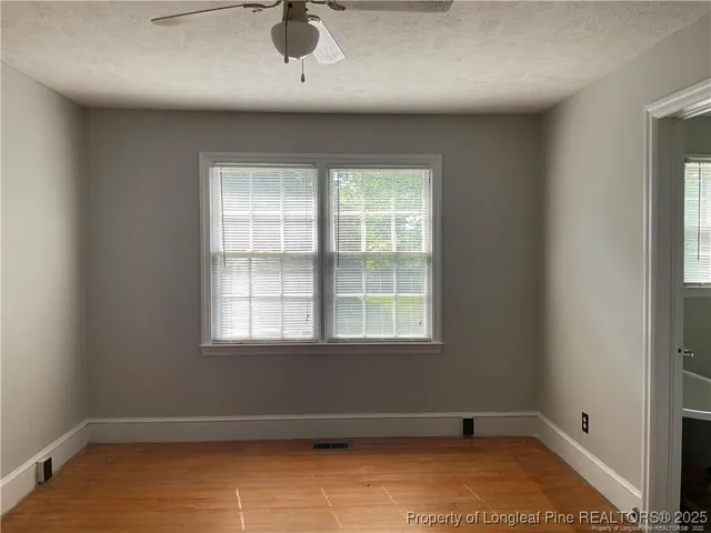 an empty room with closet and a chandelier fan