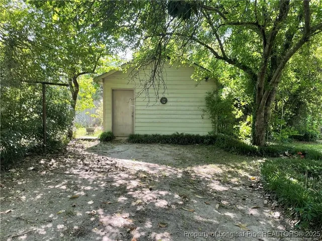 a view of a yard with plants and trees