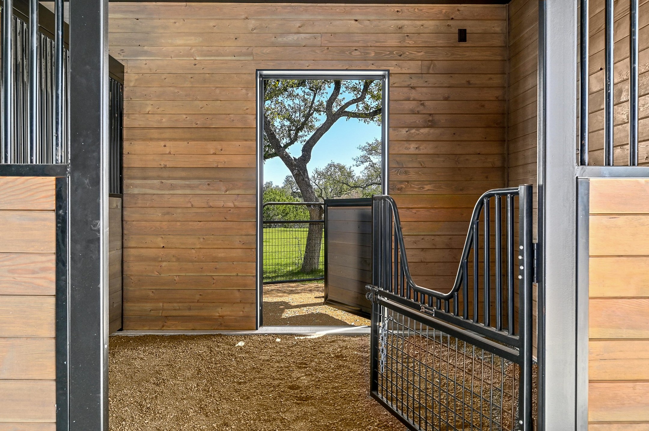 475 Happy Trail Dripping Springs, TX 78620 - Photo 39 of 40 Beautiful stall interiors with a view of the walk out. Thoughtfully placed plugs placed for cameras. Speakers throughout barn and exterior.