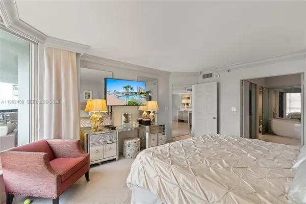 a bathroom with a tub a double vanity sink and a large mirror