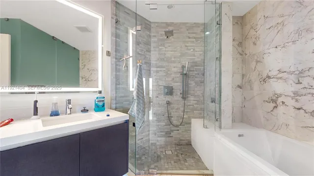a bathroom with a bathtub sink mirror and shower