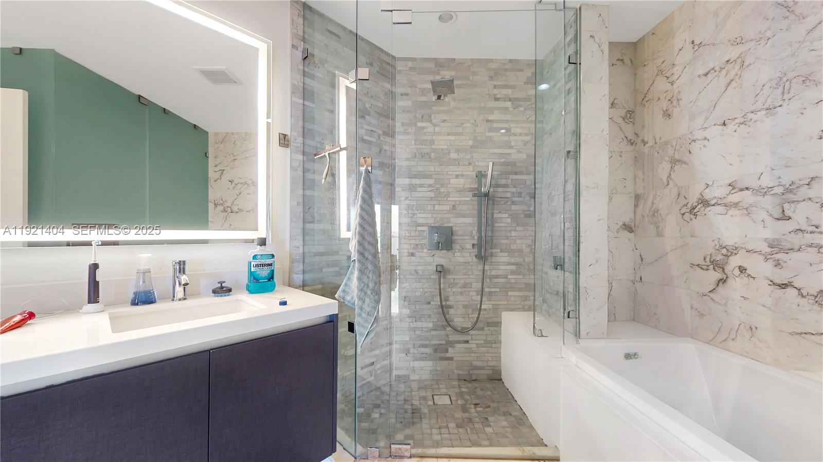 851 Northeast 1st Avenue, Unit 1508 Miami, FL 33132 - Photo 17 of 43 a bathroom with a bathtub sink mirror and shower