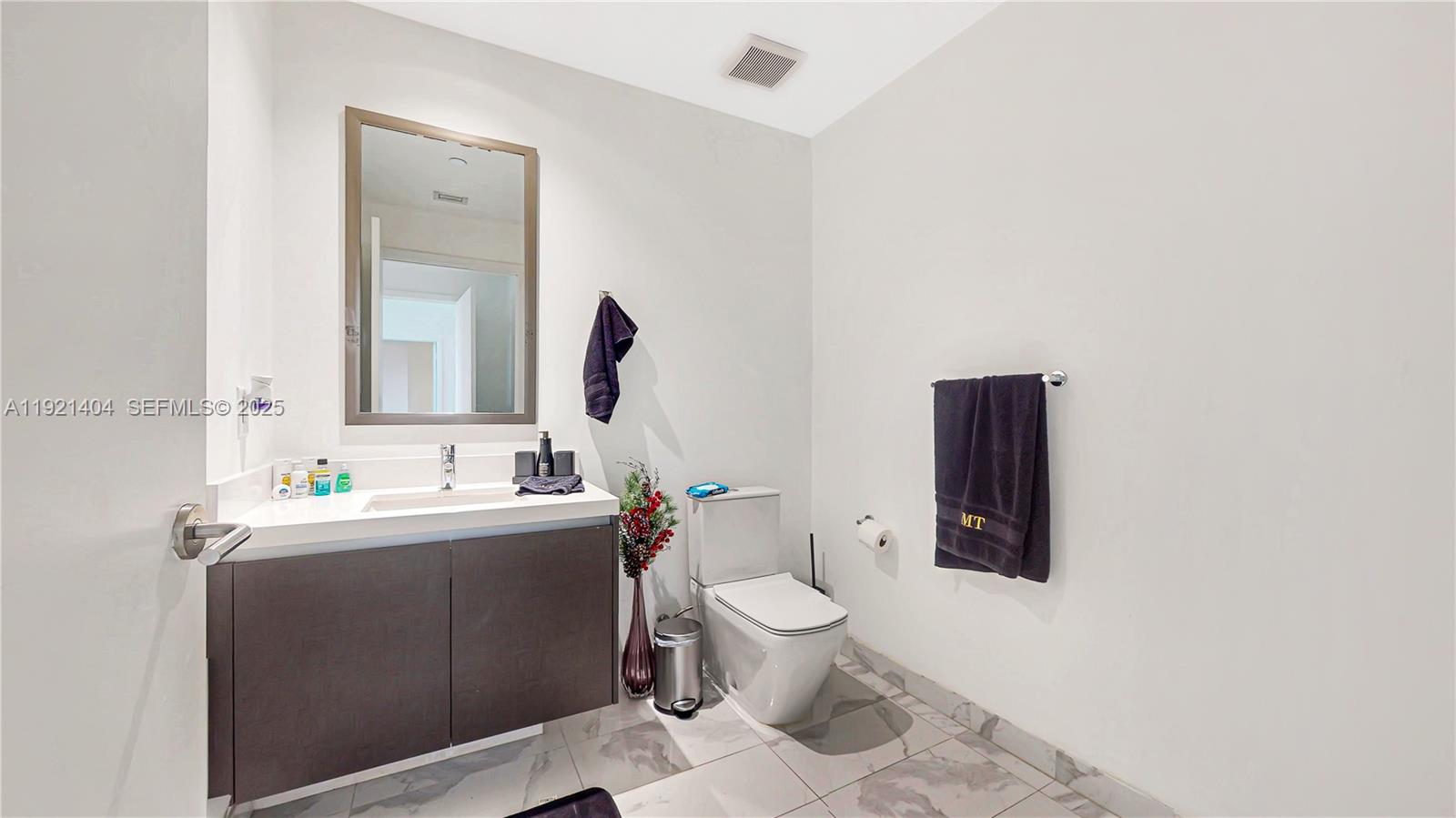 851 Northeast 1st Avenue, Unit 1508 Miami, FL 33132 - Photo 21 of 43 a bathroom with a toilet sink and mirror