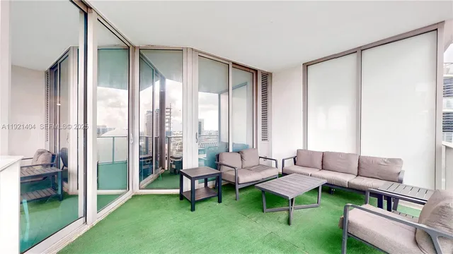 a living room with furniture and a floor to ceiling window