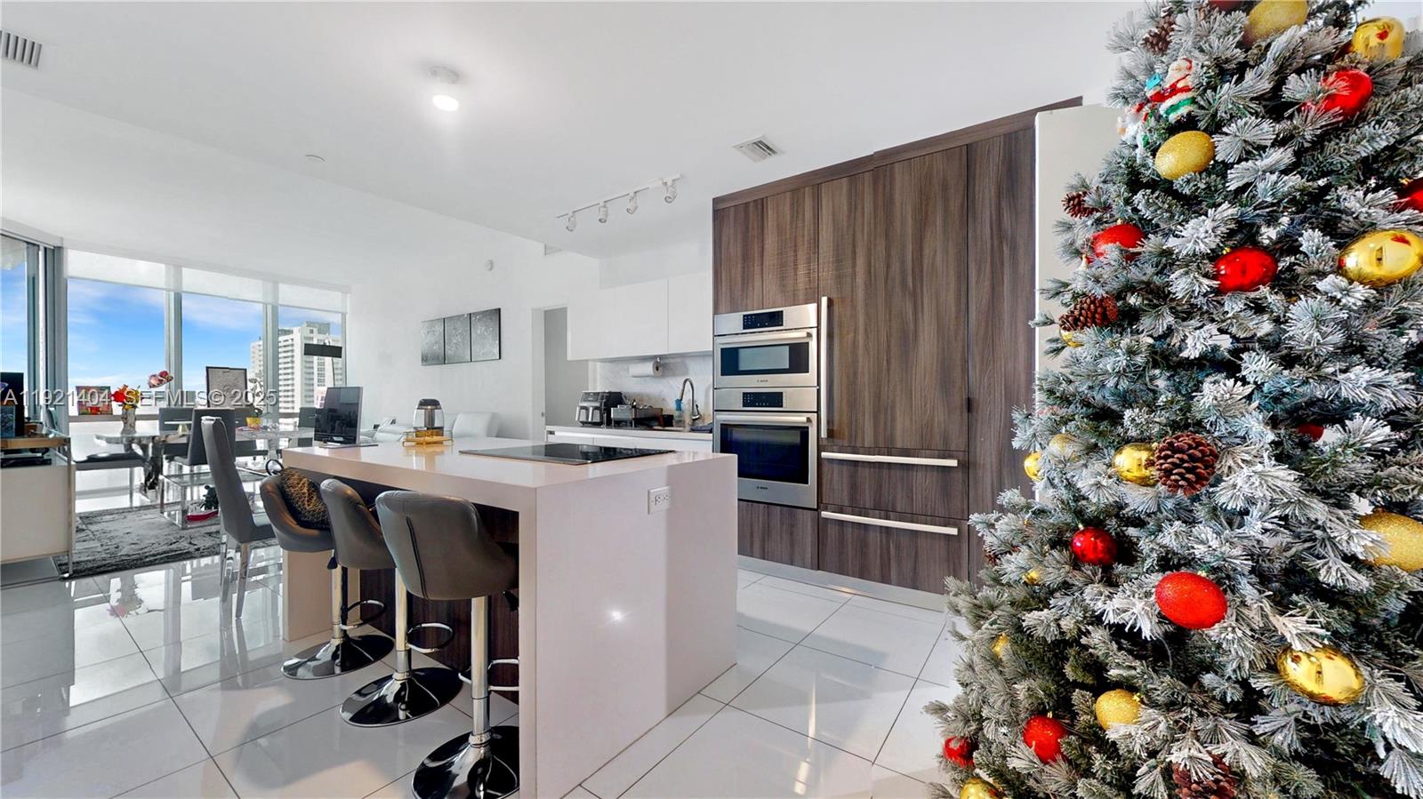 851 Northeast 1st Avenue, Unit 1508 Miami, FL 33132 - Photo 4 of 43 a kitchen with stainless steel appliances granite countertop a dining table chairs and a refrigerator