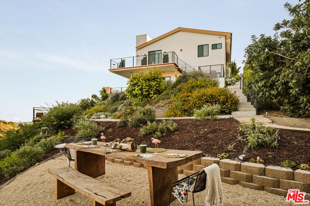 a view of a backyard with table and chairs and potted plants