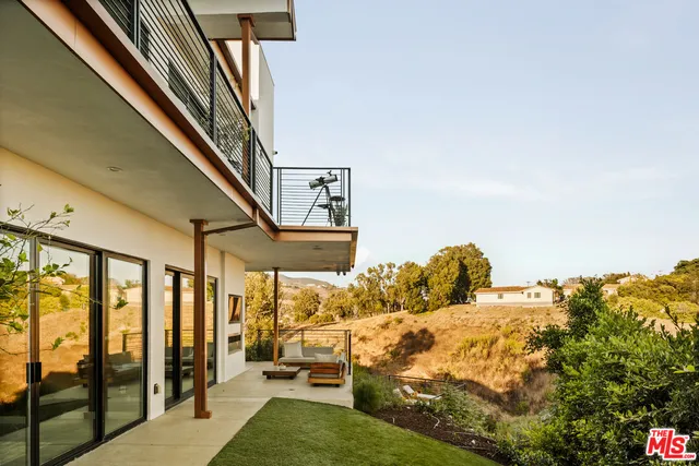 a bed sitting in a bedroom next to a large window