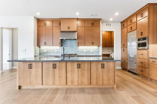 a kitchen with stainless steel appliances granite countertop a refrigerator and a stove top oven