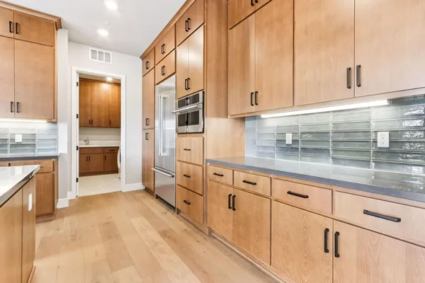 a kitchen with granite countertop white cabinets and stainless steel appliances
