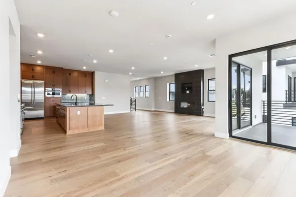 a view of a kitchen with stainless steel appliances kitchen island a large counter top and a sink
