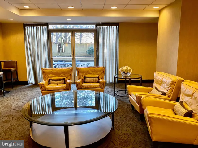 a living room with blue couches chair and a dining table with garden view