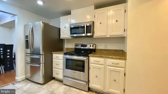 a kitchen with stainless steel appliances white cabinets and a stove