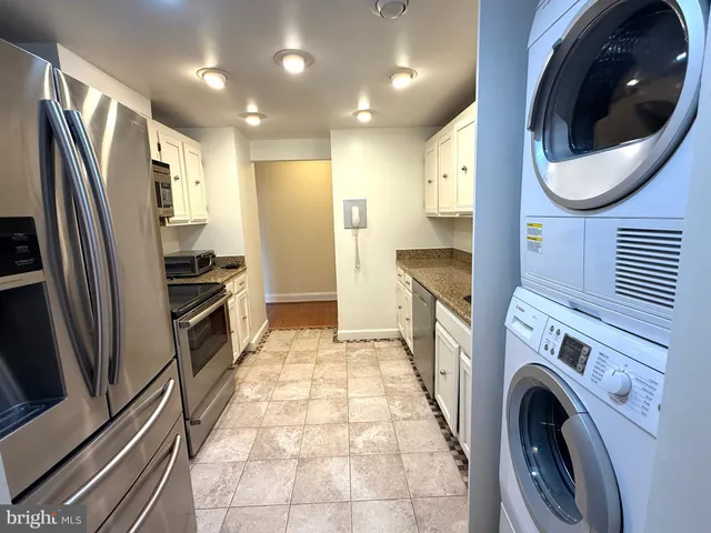 a kitchen with stainless steel appliances granite countertop a refrigerator and a stove top oven