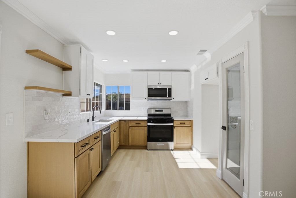 7051 Idyllwild Lane Riverside, CA 92503 - Photo 11 of 40 a kitchen with stainless steel appliances granite countertop a sink stove refrigerator and cabinets