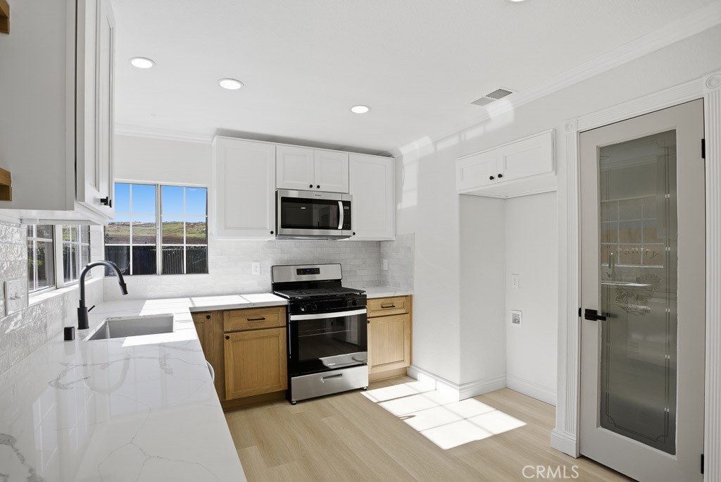 7051 Idyllwild Lane Riverside, CA 92503 - Photo 13 of 40 a kitchen with stainless steel appliances kitchen island granite countertop a stove a sink and a refrigerator