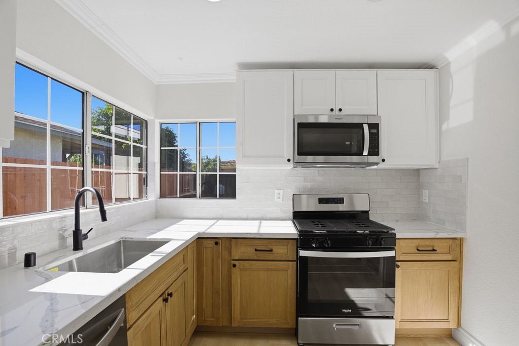 7051 Idyllwild Lane Riverside, CA 92503 - Photo 14 of 40 a kitchen with a sink and a stove top oven with wooden floor