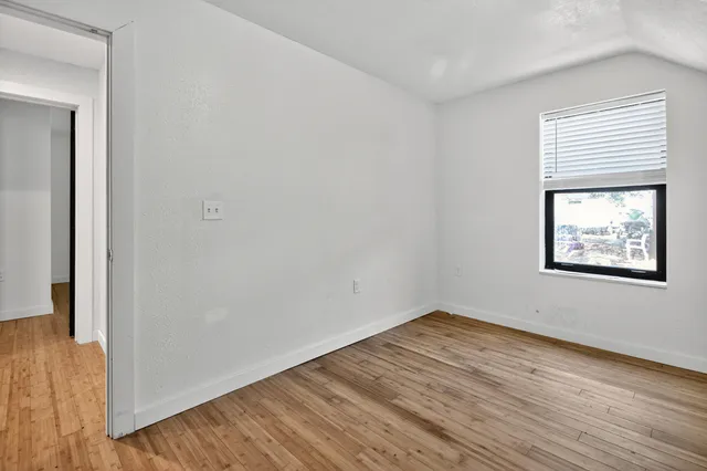 a kitchen with stainless steel appliances granite countertop a sink a stove a refrigerator cabinets and wooden floor