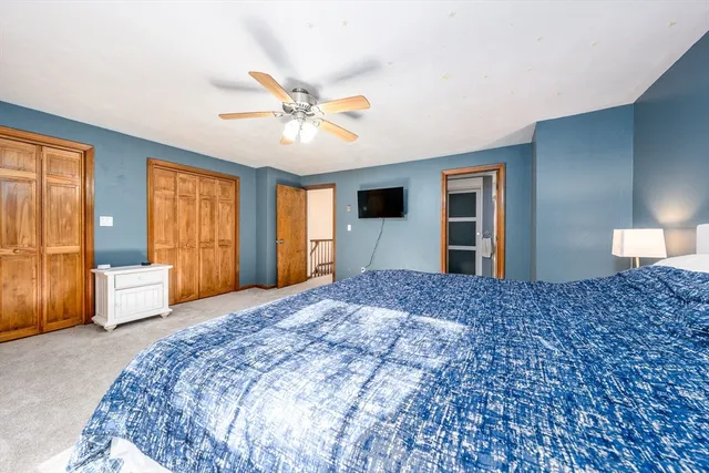 a bedroom with a bed and dresser with mirror