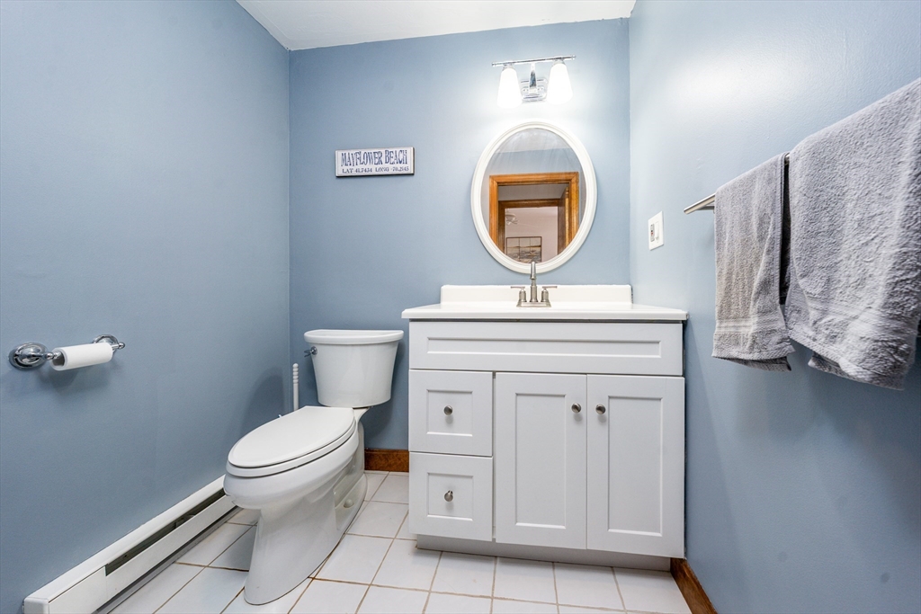 195 Falmouth Road, Unit 9D Mashpee, MA 02649 - Photo 10 of 29 a bathroom with a toilet a sink and a mirror