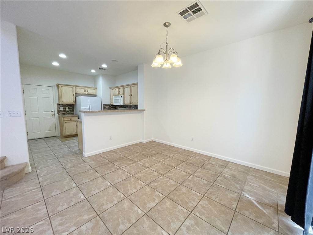 691 Principle Point Avenue Henderson, NV 89012 - Photo 12 of 30 A well-lit dining area features a graceful chandelier and tiled flooring.