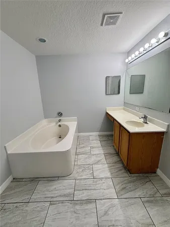an empty room with chandelier fan and windows